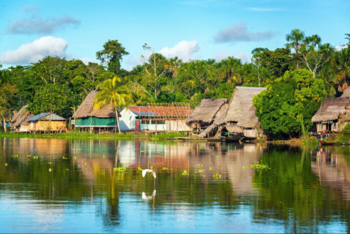 Foto de um rio na região da Amazônia com de residências ribeirinhas em seu entorno simbolizando agenda socioambiental nos primeiros cem dias de governo